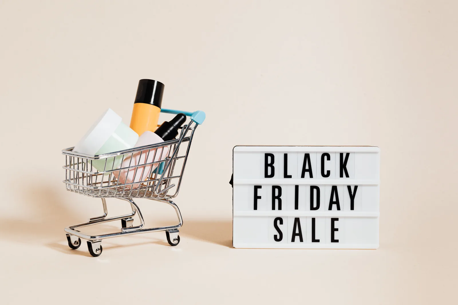 Stylish display of a mini shopping cart and a Black Friday sale sign on a beige background. Conversion rate optimization: parts worth your attention