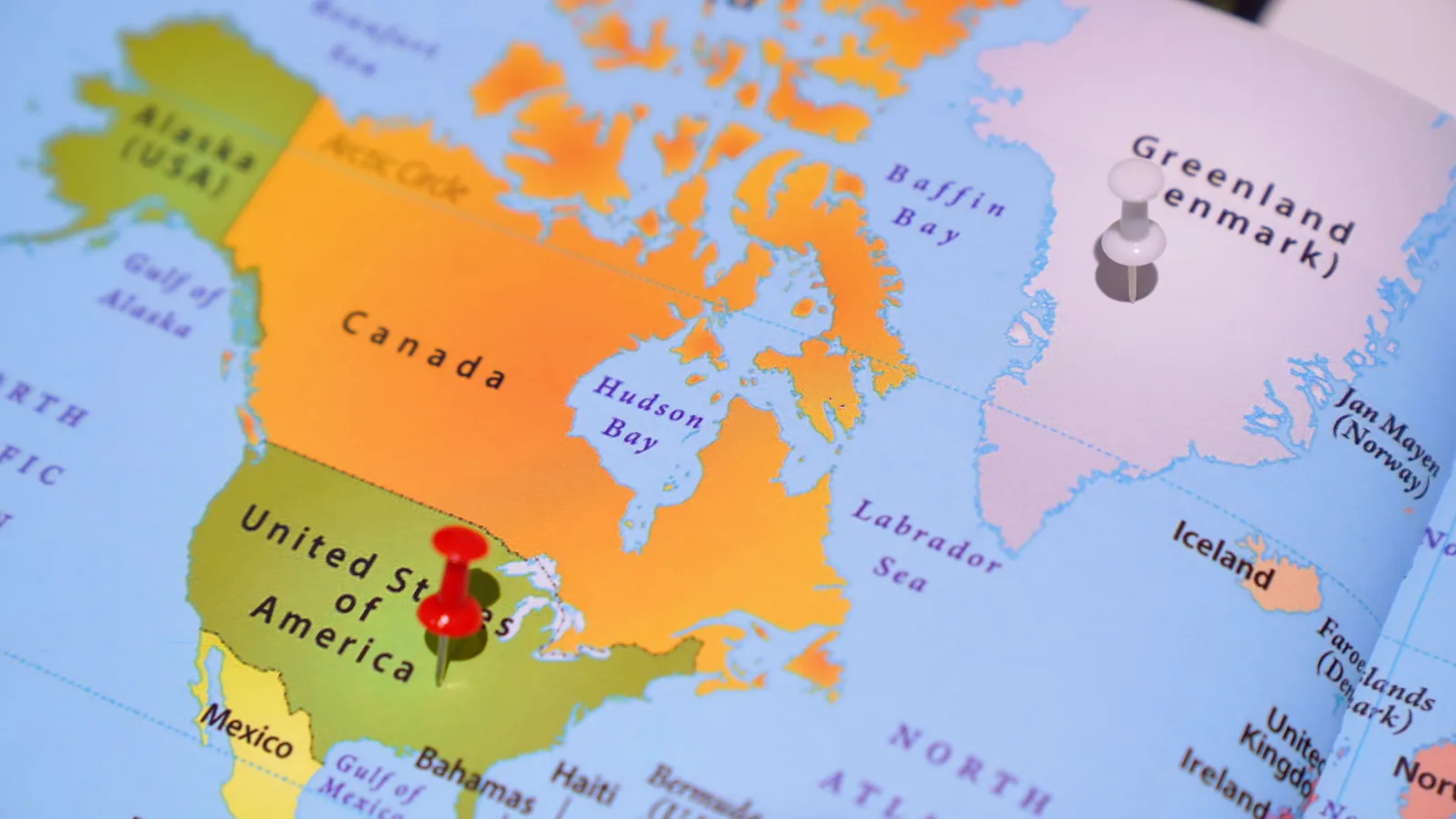 Colorful map featuring North America with pins on Greenland and USA. Cross-border omnichannel planning for US and Canadian campaigns, a practical overview
