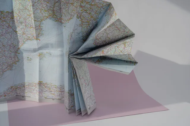 A creatively folded world map displayed in soft lighting, perfect for travel-related themes. Reading digital customer journeys with a sceptical eye