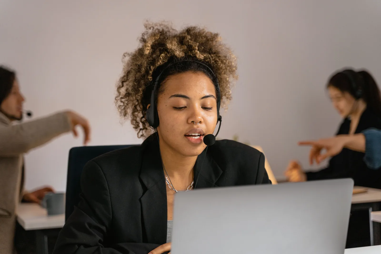 Customer support agent with headset working on laptop in office. Digital customer journeys mistakes: the traps and the way around them