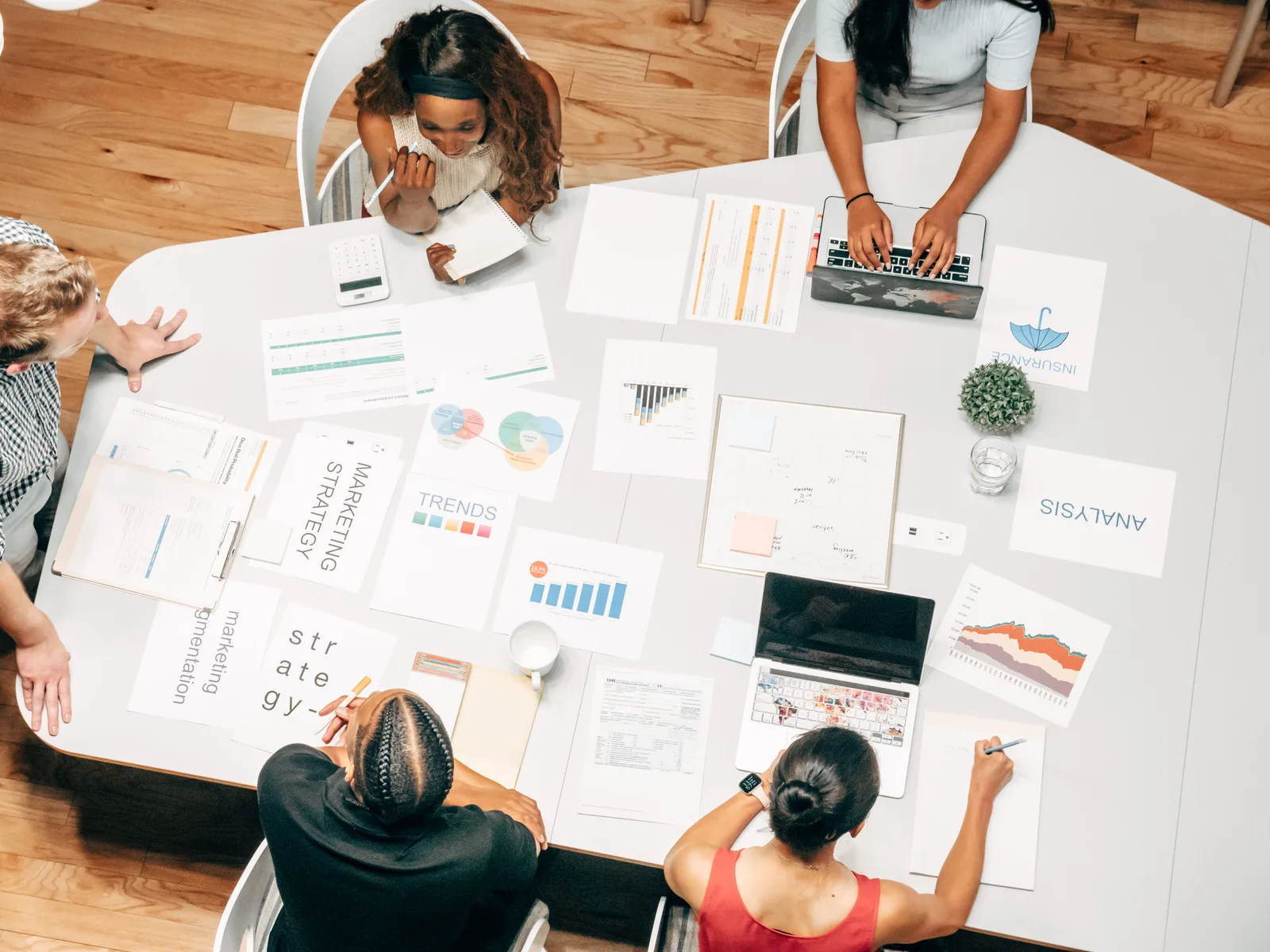 Top view of a diverse team collaborating on marketing strategies around a white table. Digital marketing campaigns: the parts worth your attention