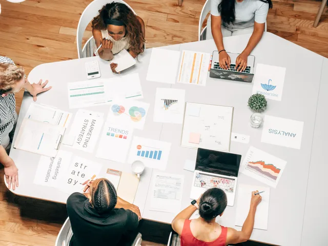 Top view of a diverse team collaborating on marketing strategies around a white table. Digital marketing campaigns: the parts worth your attention