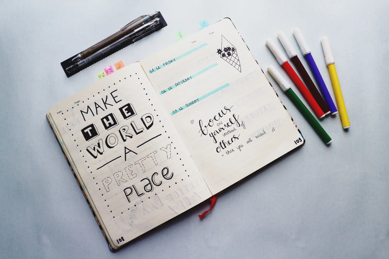 Open bullet journal with quotes and colorful markers for planning and creativity. How to define and record omnichannel marketing benchmarks
