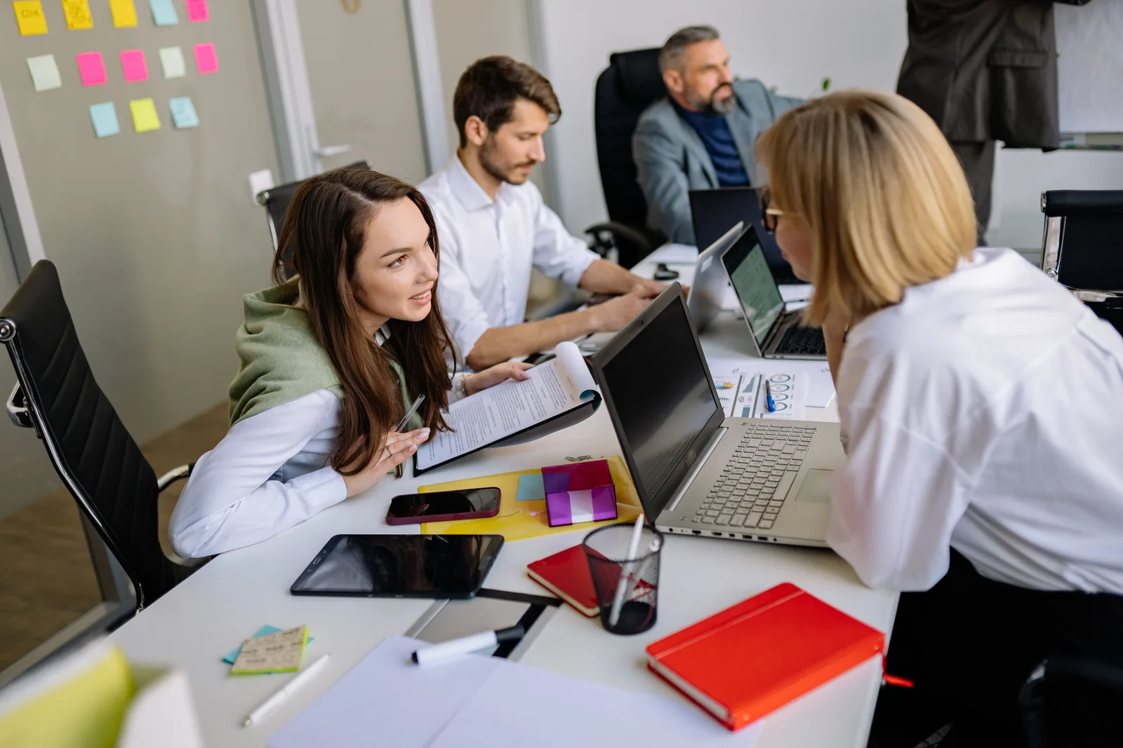 Team discussion in a modern office setting, focusing on cooperation and strategy development. Guide: omnichannel media planning workflow for small teams