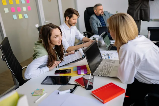 Team discussion in a modern office setting, focusing on cooperation and strategy development. Guide: omnichannel media planning workflow for small teams